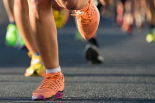 Personer joggar på asfalt.